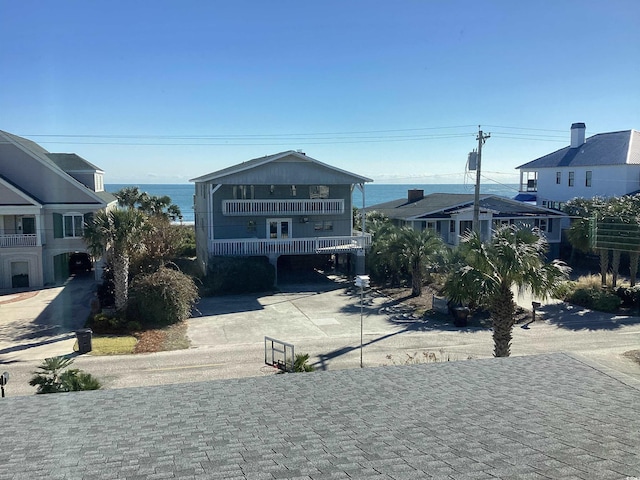 view of front facade featuring a balcony, a water view, and a carport