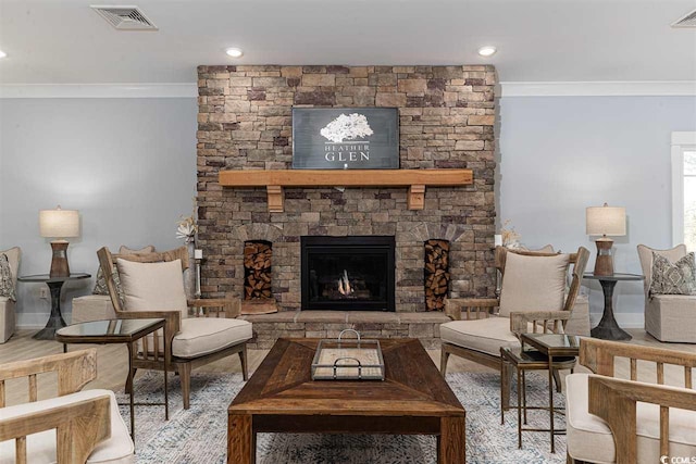 sitting room with a stone fireplace, wood-type flooring, and ornamental molding