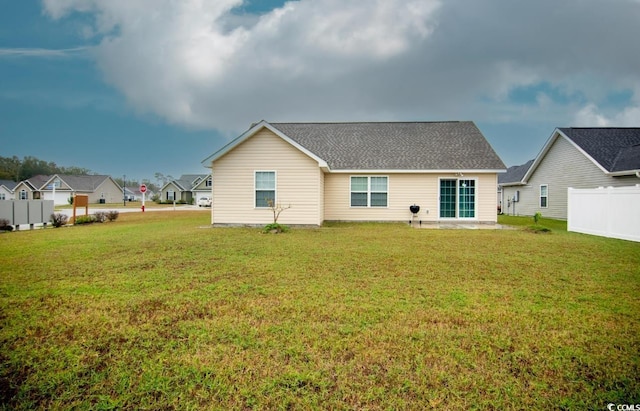 rear view of house featuring a lawn