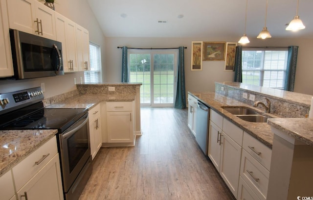 kitchen with light stone counters, sink, white cabinets, and stainless steel appliances