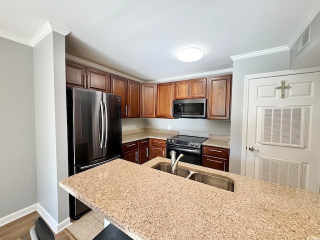 kitchen featuring light stone countertops, sink, stainless steel appliances, light hardwood / wood-style floors, and ornamental molding