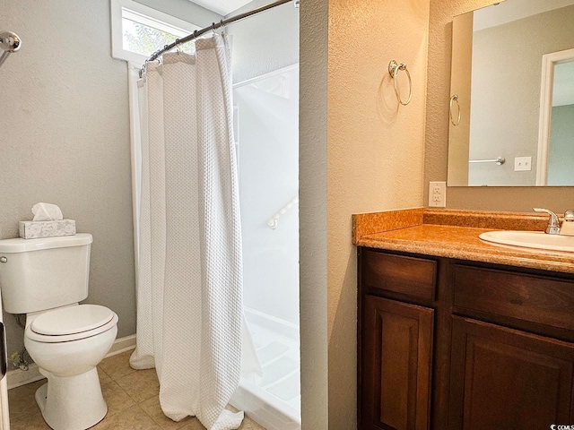 bathroom featuring tile patterned flooring, vanity, toilet, and walk in shower