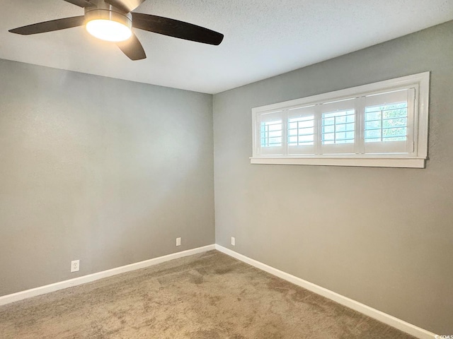 carpeted spare room with ceiling fan and plenty of natural light