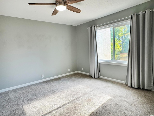 spare room with ceiling fan and light colored carpet