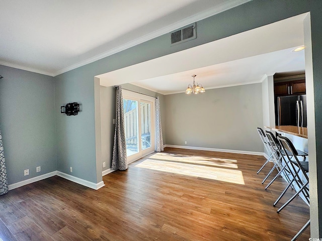 interior space with a chandelier, crown molding, and wood-type flooring