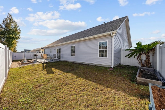 rear view of house featuring a yard and a patio area