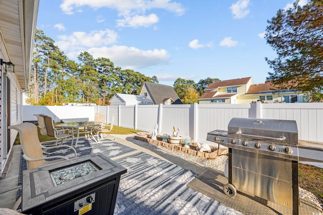 wooden terrace featuring area for grilling and an outdoor fire pit