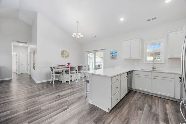 kitchen featuring stainless steel dishwasher, kitchen peninsula, sink, and white cabinets