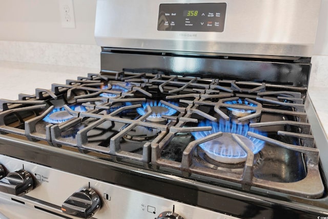 details with decorative backsplash and stainless steel gas stove