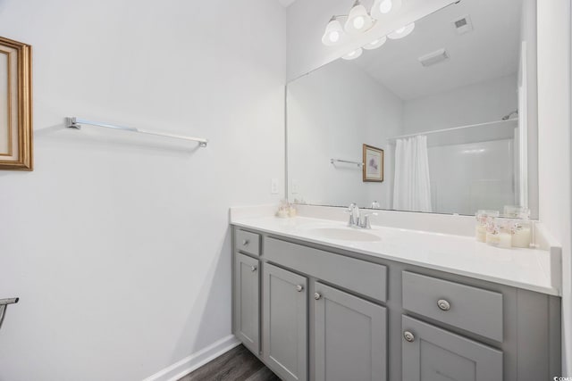 bathroom with vanity, curtained shower, and hardwood / wood-style floors