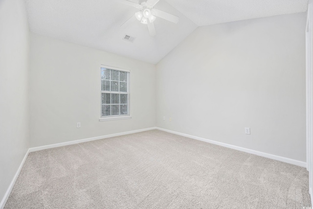 carpeted spare room featuring vaulted ceiling and ceiling fan