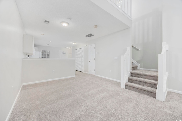 unfurnished living room with light colored carpet