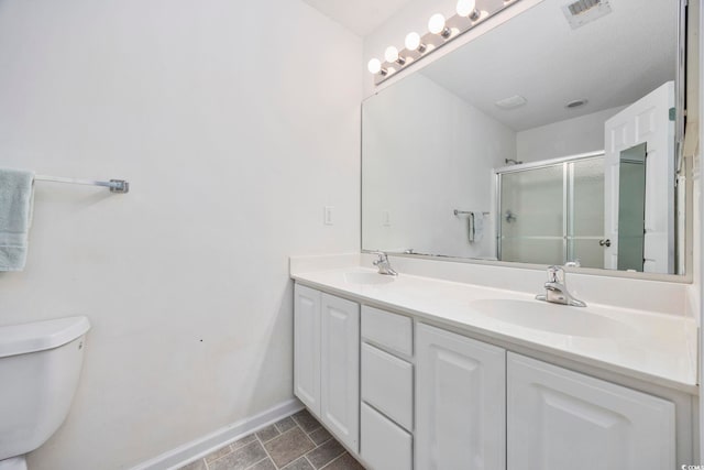 bathroom featuring vanity, toilet, and an enclosed shower