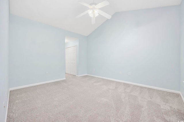 carpeted empty room with ceiling fan and vaulted ceiling