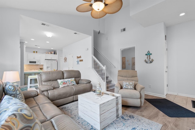 living room with vaulted ceiling, light hardwood / wood-style flooring, and ceiling fan