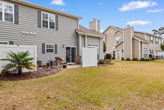 rear view of house with a lawn, central AC unit, and a patio