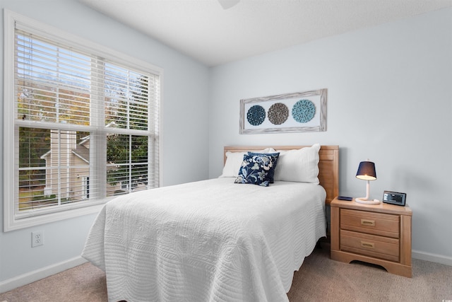 bedroom featuring light carpet and multiple windows