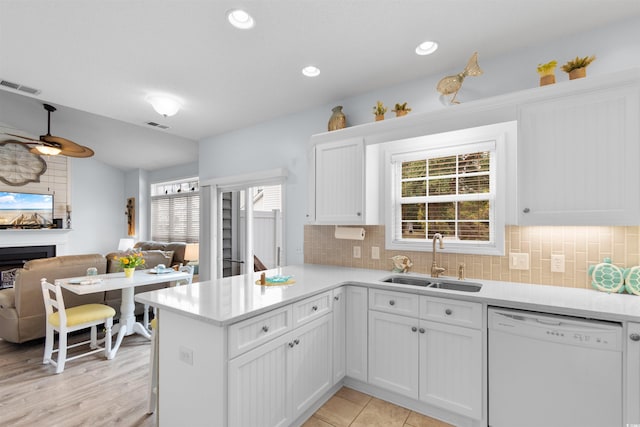 kitchen featuring kitchen peninsula, white cabinets, sink, and white dishwasher