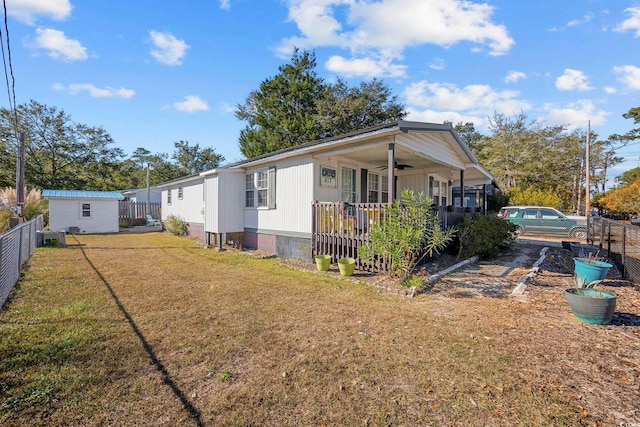 view of front of home featuring a porch, a shed, and a front lawn