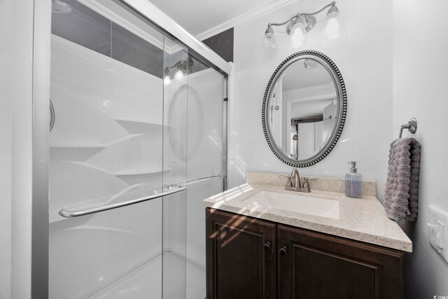 bathroom with walk in shower, vanity, and ornamental molding