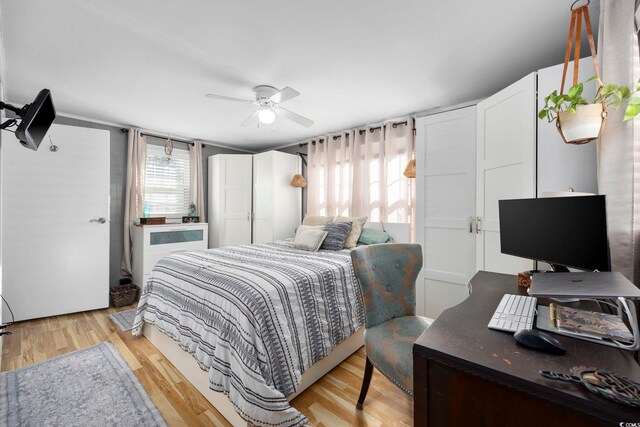 bedroom with multiple windows, ceiling fan, and light wood-type flooring