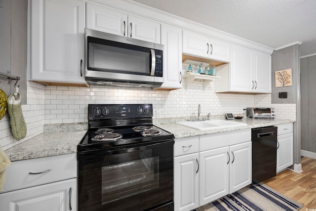 kitchen featuring backsplash, sink, black appliances, light hardwood / wood-style flooring, and white cabinetry