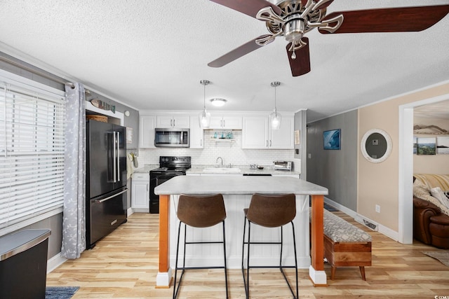 817 Wayne St, North Myrtle Beach, SC 29582 - kitchen with black appliances, a sink, light countertops, ceiling fan, and white cabinetry