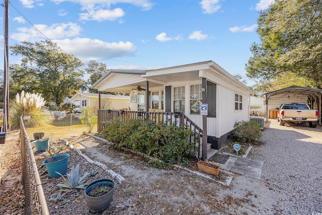 817 Wayne St, North Myrtle Beach, SC 29582 - view of front of property with covered porch, a ceiling fan, a carport, cooling unit, and gravel driveway