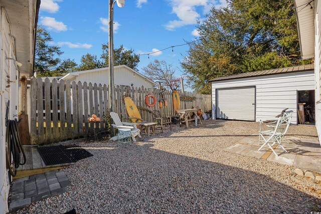 view of yard featuring a garage and an outdoor structure