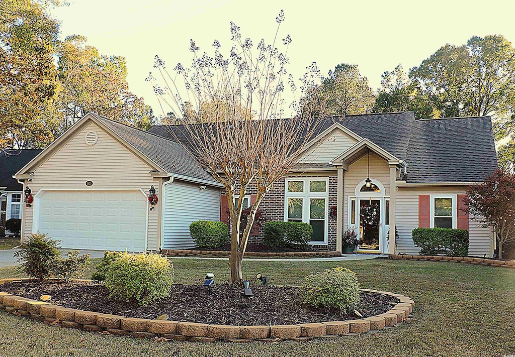 view of front facade featuring a lawn and a garage