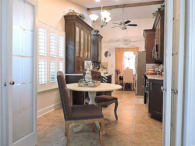 tiled dining space with ceiling fan with notable chandelier and vaulted ceiling