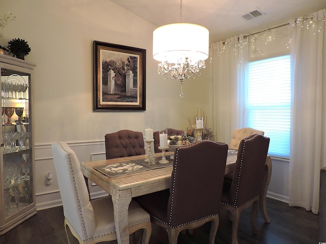 dining area with a chandelier, dark wood-type flooring, and vaulted ceiling