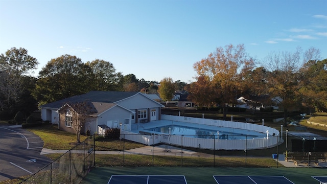 view of swimming pool with tennis court