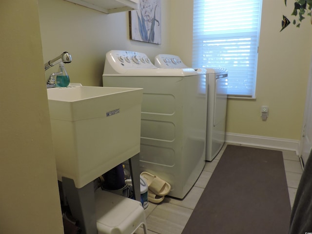 washroom featuring washing machine and clothes dryer, sink, and light tile patterned flooring