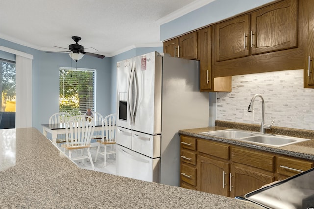 kitchen featuring ceiling fan, sink, stainless steel appliances, decorative backsplash, and ornamental molding