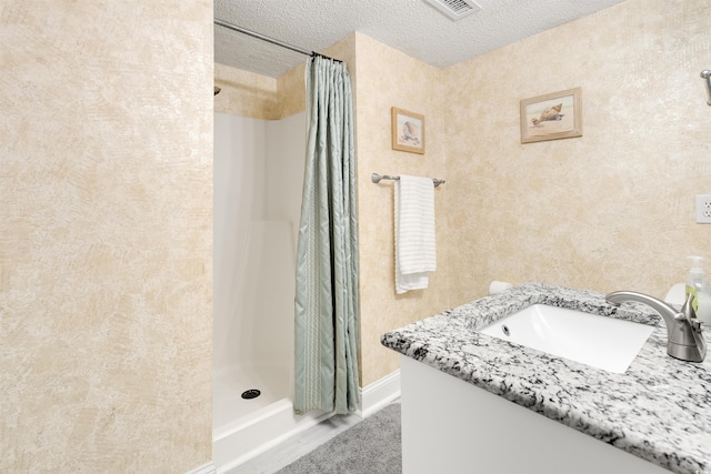 bathroom with vanity, a textured ceiling, and a shower with shower curtain