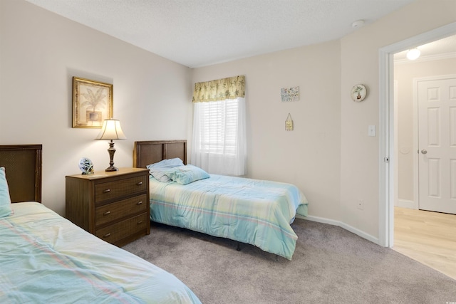 bedroom featuring light colored carpet and a textured ceiling