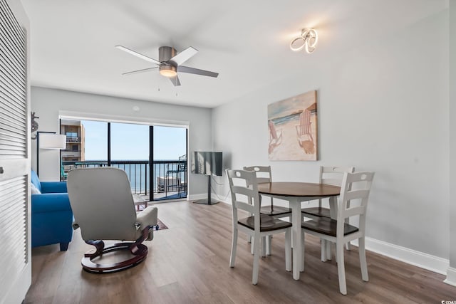 dining area with hardwood / wood-style flooring and ceiling fan