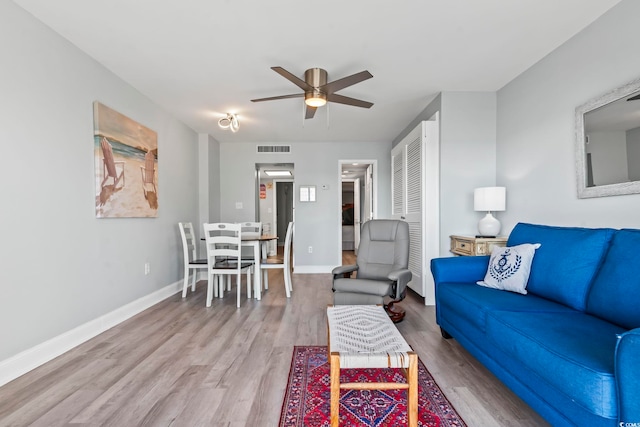 living room featuring ceiling fan and light hardwood / wood-style floors