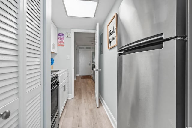 kitchen featuring appliances with stainless steel finishes, light wood-type flooring, and white cabinetry