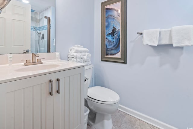 bathroom featuring toilet, vanity, tile patterned floors, and a shower with shower door