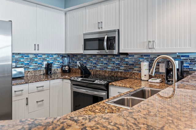 kitchen featuring white cabinets, dark stone countertops, and appliances with stainless steel finishes