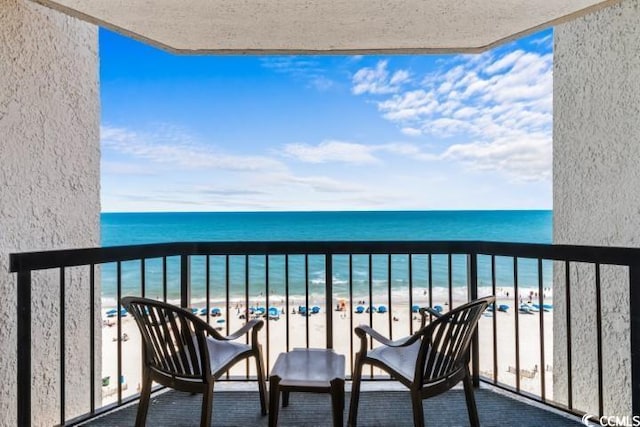 balcony featuring a water view and a view of the beach