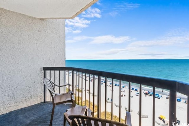 balcony featuring a beach view and a water view