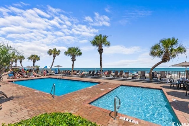 view of pool with a patio area and a water view