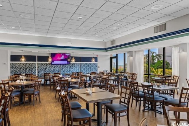 dining space with a paneled ceiling and hardwood / wood-style floors