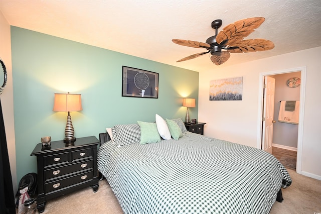 carpeted bedroom with connected bathroom and ceiling fan