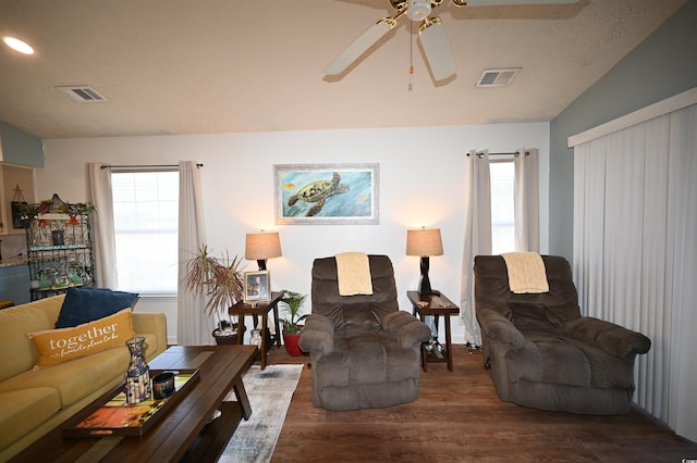 living room with vaulted ceiling, dark wood-type flooring, ceiling fan, and a textured ceiling