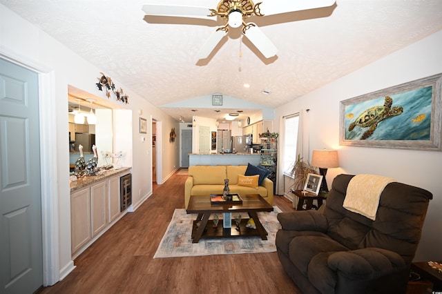 living room featuring dark hardwood / wood-style flooring, vaulted ceiling, beverage cooler, and a textured ceiling