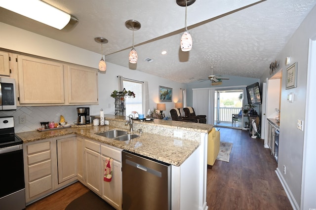 kitchen featuring stainless steel appliances, sink, a textured ceiling, and kitchen peninsula